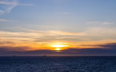 Bright Sunset Over Tranquil Pacific Waters with Golden and Orange Skies
