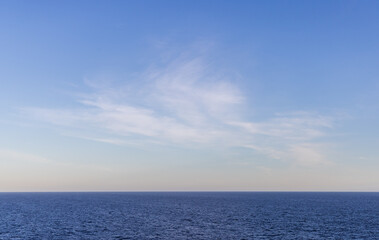 Obraz premium Serene View of Ocean with Clear Sky and Wispy Clouds at Daytime