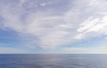 Expansive Ocean Horizon Meeting Sky with Thin White Clouds Above