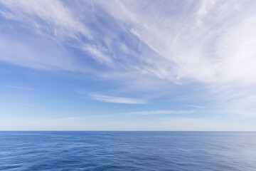 Obraz premium Expansive Blue Ocean With a Serene Cloudscape on a Sunny Day
