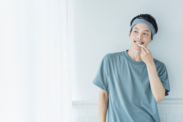 朝の洗面台で歯を磨く若い男性