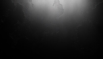 Obraz premium Close-up of a black textured surface with subtle lighting highlighting uneven, rough patches creating a moody, abstract appearance