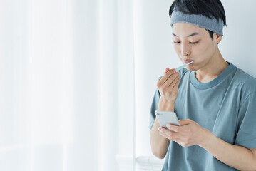 朝の洗面台で歯を磨く若い男性