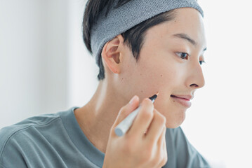 コンシーラーを塗る若い男性