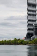 Canadian flag blowing in wind along Humber Bay on Lake Ontario, Toronto