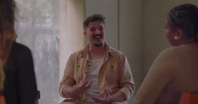 Man speaking from the heart in therapy group, using expressive gestures to share personal story while surrounded by attentive and supportive participants