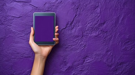 Isolated hand holding black tablet device against a vibrant textured violet wall