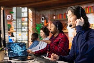 Team of multiethnic call center workers using AI chatbot to reply to common customer queries....