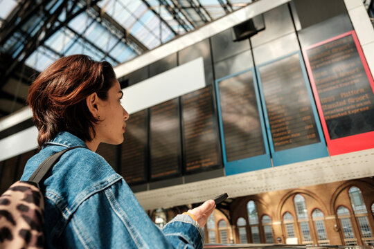 Young woman checking train schedule at international station