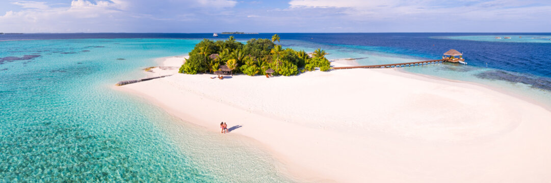 Aerial panoramic of couple on a beach on a small island in the Maldives