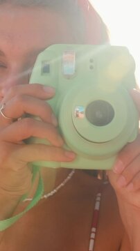 Young woman enjoys the beach atmosphere as bright sunlight creates a warm glow. Her joyful expression radiates happiness, capturing the essence of summer fun with friends.