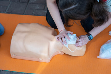 Direct heart massage. First aid training on a medical dummy. Woman doing CPR on a mannequin for training