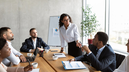 Businesswoman Giving Speech On Business Meeting With Colleagues, Discussing Work Ideas And Projects, Making Presentation Standing In Modern Office. Teamwork, Entrepreneurship, Corporate Meeting