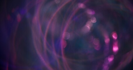 Blurred sparks. Ray circles. Colorful blue purple glow bokeh light lens flare smooth texture rays floating on dark abstract modern background.