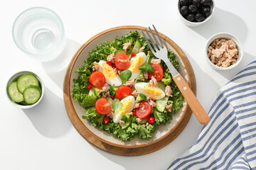Ready salad with tuna on a wooden board.