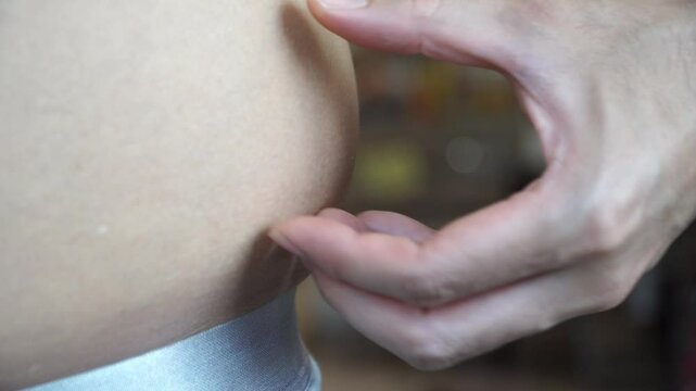 Close up man measuring stomach fat with her hands isolated and white background with clipping path	
