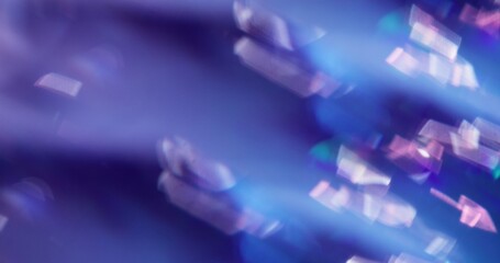 Defocused shine particles. Crystal glow. Gleam white sparks lens flare twirling on blue purple...