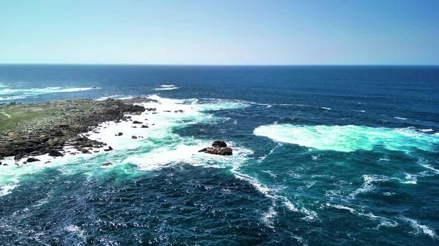 Experience breathtaking and stunning aerial views of rocky coasts and vibrant turquoise waves beneath a serene blue sky