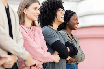 Closeup of international group of people making strike on street, holding hands, showing their strong unity, demanding from government saving planet, reducing pollution. Riot, demonstration, strike