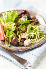 Healthy and tasty salad with feta cheese, various tomatoes, olives, cucumber, onion and lettuce.