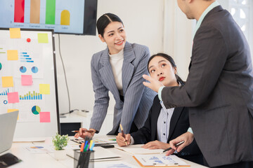 Group of Asian business people discussing documents and working happily