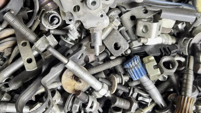 A close-up view of assorted metallic hardware, showcasing various fasteners, nuts, and bolts in a chaotic arrangement.