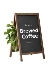 An inviting chalkboard sign advertising fresh brewed coffee is displayed next to a potted plant against a crisp white background, creating a warm, caffeinated welcome.