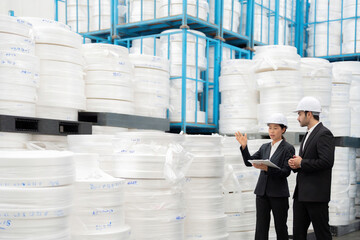 As leaders in their field, a European male engineer and an Asian female engineer analyze production data, integrating technology to support industry growth in the global market.