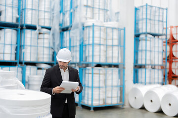 A European male engineer examines raw plastic materials delivered to the industrial plant, ensuring...