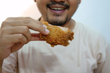 Man Enjoying Crispy Fried Chicken With a Smile on His Face