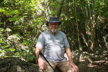 Older trekking adventure carries backpacks poles enjoying nature expression looks into the distance observing and possibly guide trekking and trail ecotourism adventure concept.