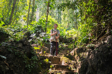 Young boy outdoor hiking backpack and walking stick looks into the distance observing and possibly guide trekking and trail exploration holiday ecotourism concept.