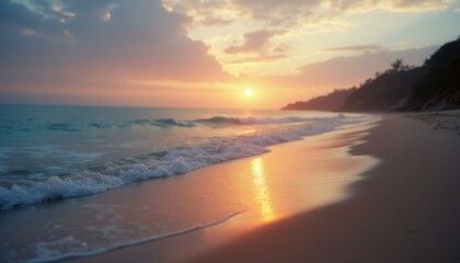 Waves gently roll onto a pristine sandy beach under the soft glow of the setting sun, creating a peaceful coastal scene