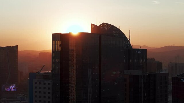 Golden hour aerial view of Ulaanbaatar city skyline in Mongolia with sunset over the mountains and modern high-rise buildings