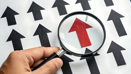 Finding your competitive edge Red arrow points the way to success viewed under a magnifier with