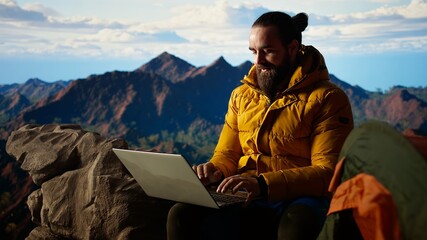 Tech savvy hiker having a technology obsession and working on a mountain peak, always connected to the internet with strong signal. Workaholic traveler does remote work on a hill. Camera A.