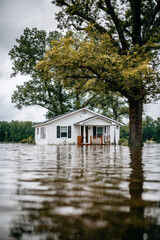 Obraz premium Flooded single-story home from rainstorm representing natural disaster, destruction, and climate emergency