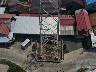 Electricity generated from generation is distributed through transmission towers before reaching consumers. Transmission towers pass on the roof of densely populated residential house in a city