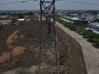 Electricity generated from generation is distributed through transmission towers before reaching consumers. Transmission towers pass on the roof of densely populated residential house in a city
