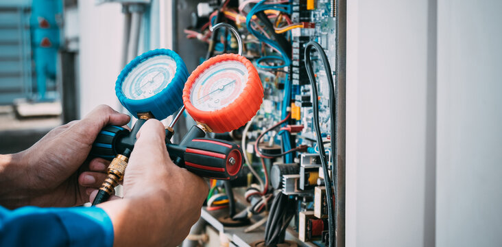 Technician is checking air conditioner refrigerant leak.