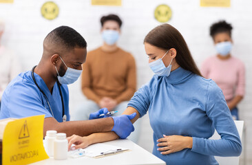 Covid-19 Vaccination. Black Doctor Making Coronavirus Vaccine Injection To Pregnant Woman Sitting In Hospital Room. Covid 19 Population Immunization Campaign, Corona Virus Medicine Cure And Treatment