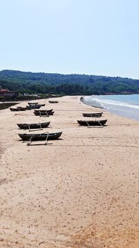 Vertical drone shot over traditional Dhoni fishing vessels, on a beach in India