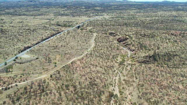 Drone view looking north along the Charles River and Stuart Highway at Irlpme, a northern suburb of Alice Springs, Mparntwe, Northern Territory, Australia. August 2022.