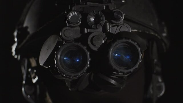 Closeup of special forces trooper using advanced night vision binocular optics