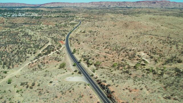 Aerial view looking south along the Stuart Highway at Irlpme, with Alice Springs, Mparntwe, in the distance. Northern Territory, Australia. August 2022.