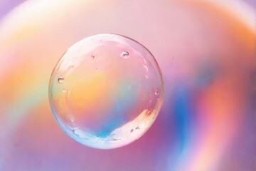 Rainbow Soap Bubble Floating with Water Droplets in Dreamy Gradient Background