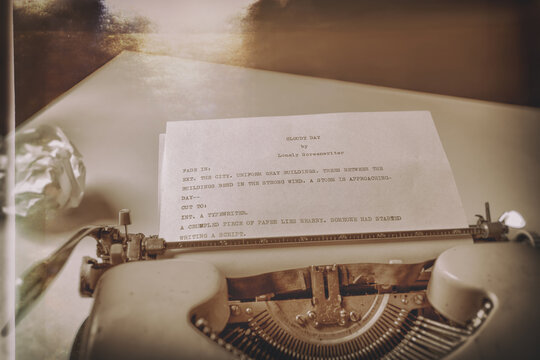 An imaginary script by an imaginary writer on a sheet of paper inserted into a vintage typewriter. A crumpled piece of paper lies nearby.  Selective focus. Post-processed to look like an old photo.