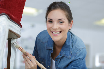 a woman is painting chair