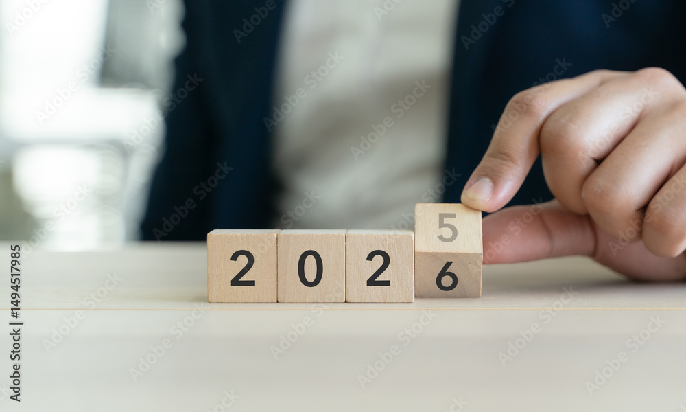 Poster transitioning from 2025 to 2026 with wooden blocks. challenge target business for the upcoming year.