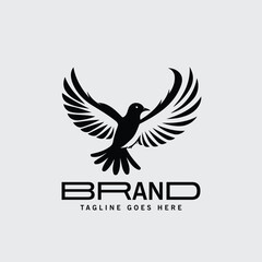 Fototapeta premium Black silhouette of a bird in flight against a light gray background. Abstract design with stylized wings. Modern logo design for a brand.